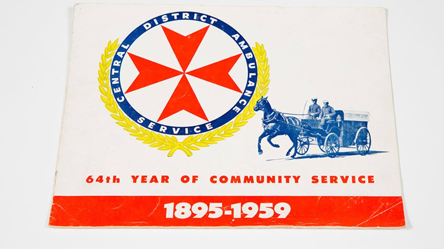A booklet featuring an illustration of a horse and carriage on its cover and an old logo of the ambulance service.