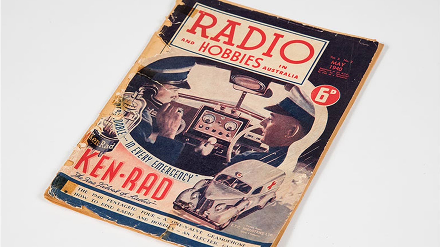 A vintage magazine illustrating two first responders driving an old ambulance.