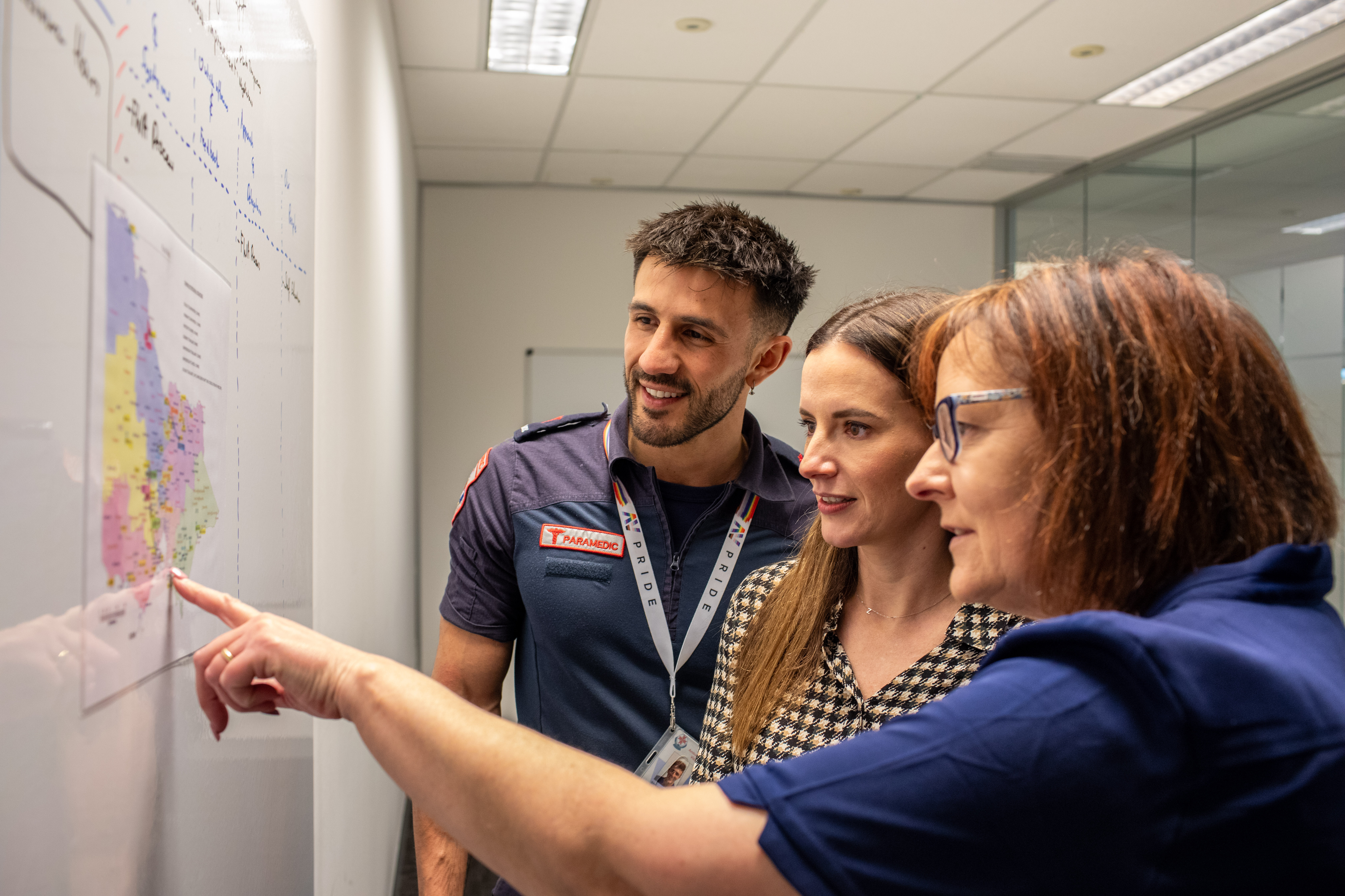 Three AV staff looking at a map of the Victorian regions