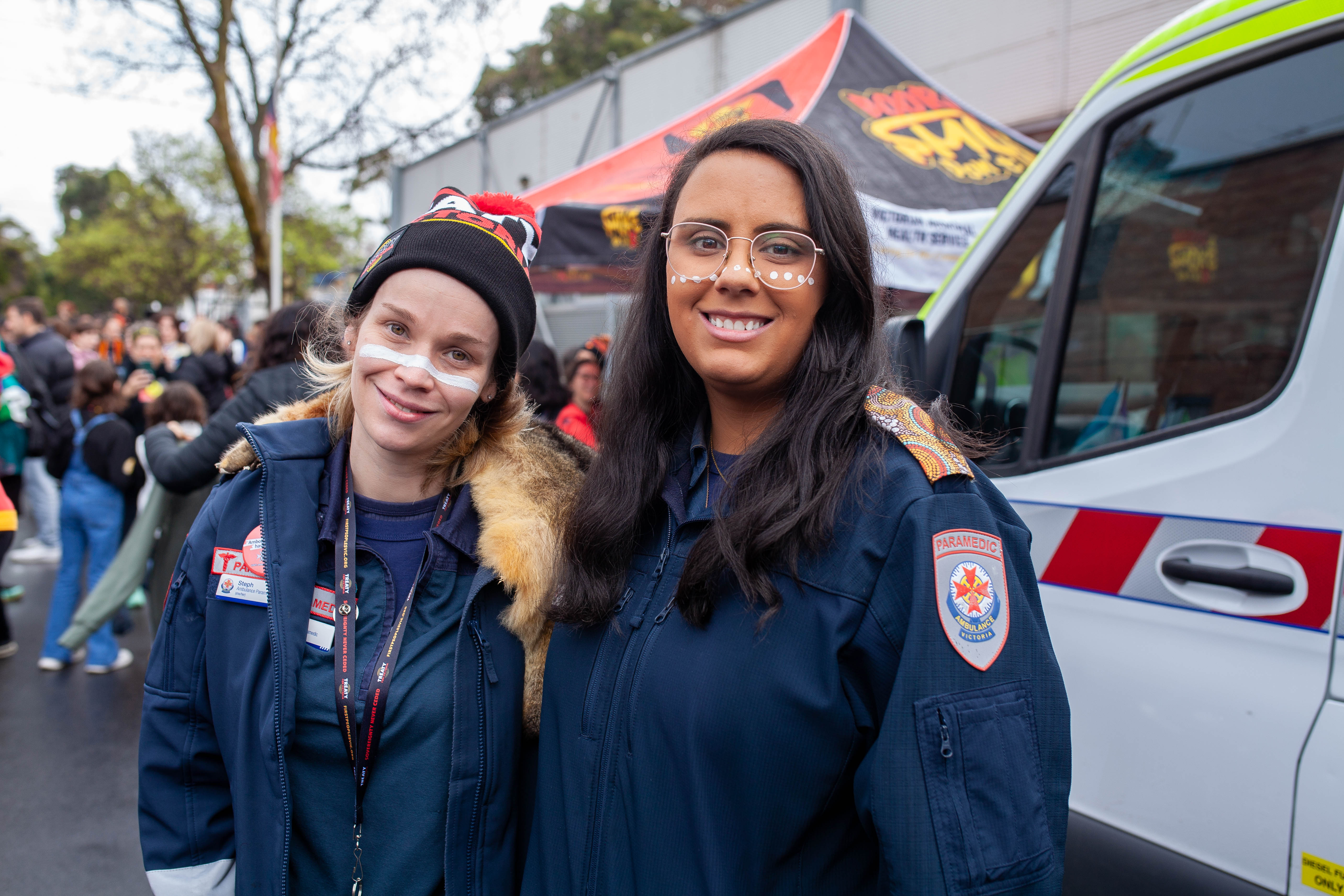 Two paramedics standing near ambulance.