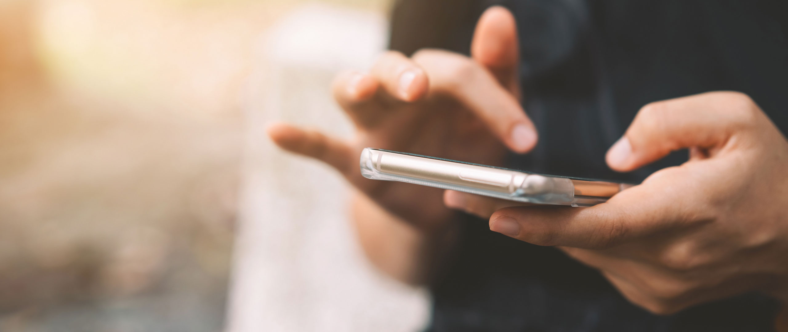 A person holding a mobile phone in their hand.
